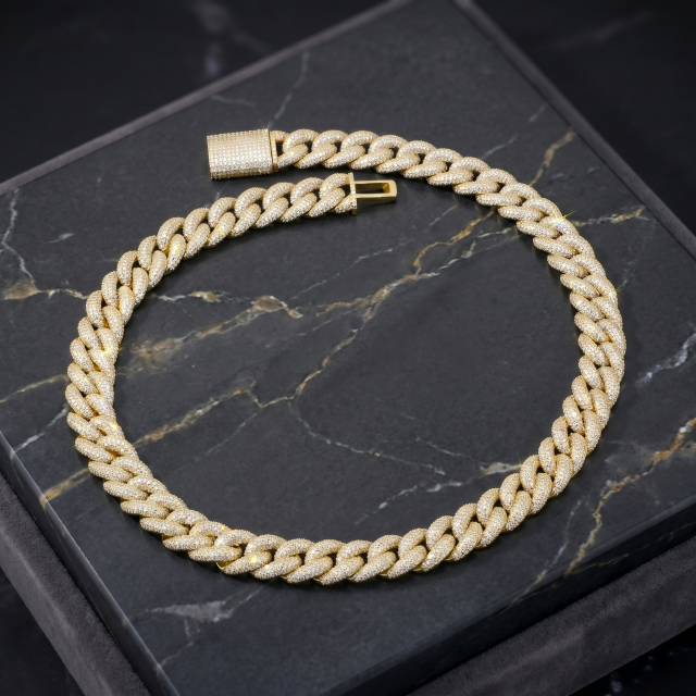 Stunning 16mm iced-out moissanite Cuban chain in gold finish resting on an elegant black marble display surface.