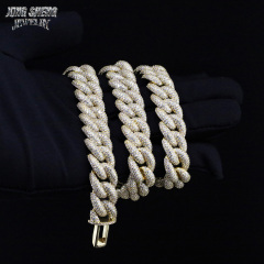 Gloved hand holding a heavy, multiple-layered 16mm iced out moissanite Cuban link chain in yellow gold finish.