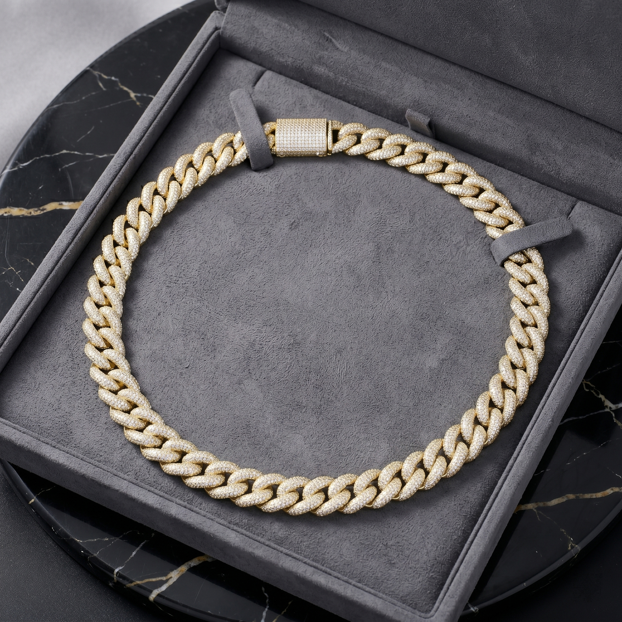 A luxurious 16mm gold moissanite Cuban link chain presented in a premium grey jewelry gift box reflecting bright light.
