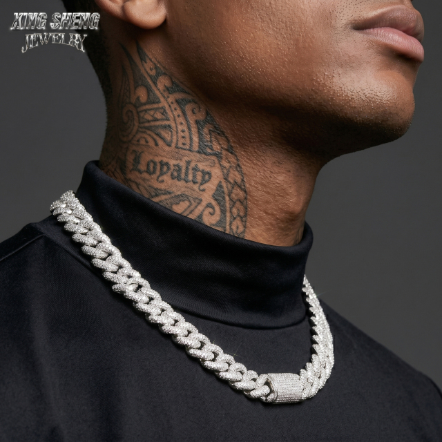 Profile shot of a fashion-forward male model wearing the thick 16mm iced out moissanite Cuban link chain, demonstrating how the rhodium-plated silver perfectly contours the neckline for a bold streetwear aesthetic.