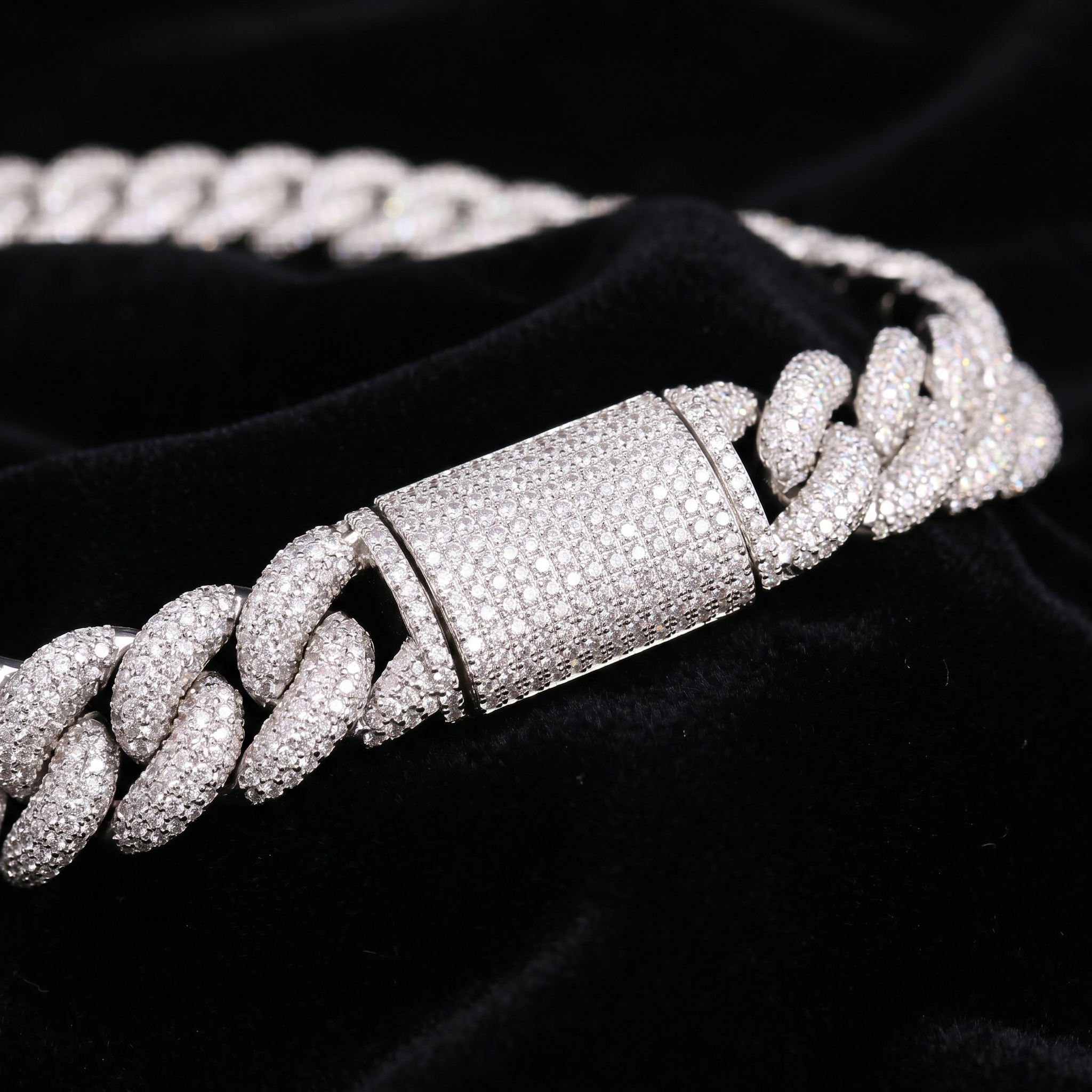 Extreme close-up of the heavy 16mm S925 silver moissanite Cuban link chain resting on black velvet, focusing on the precision micro-pavé VVS moissanite setting and the highly secure double-locking box clasp.