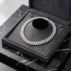 The masterpiece 16mm S925 silver rhodium-plated moissanite Cuban link chain resting elegantly on a plush grey display bust inside a custom engraved luxury presentation box.