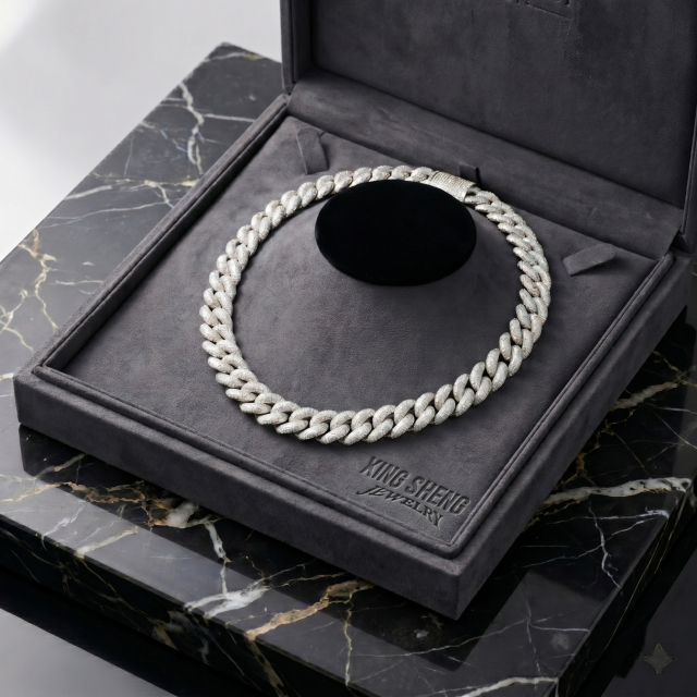 The masterpiece 16mm S925 silver rhodium-plated moissanite Cuban link chain resting elegantly on a plush grey display bust inside a custom engraved luxury presentation box.