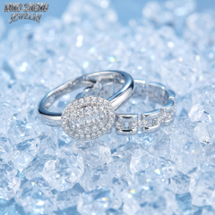 Oval halo baguette and round moissanite bridal set in S925 silver resting on sparkling ice crystals.