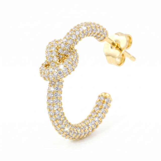 Side profile of a gold-plated moissanite love knot earring showcasing the intricate c-shape hoop design and secure post.

