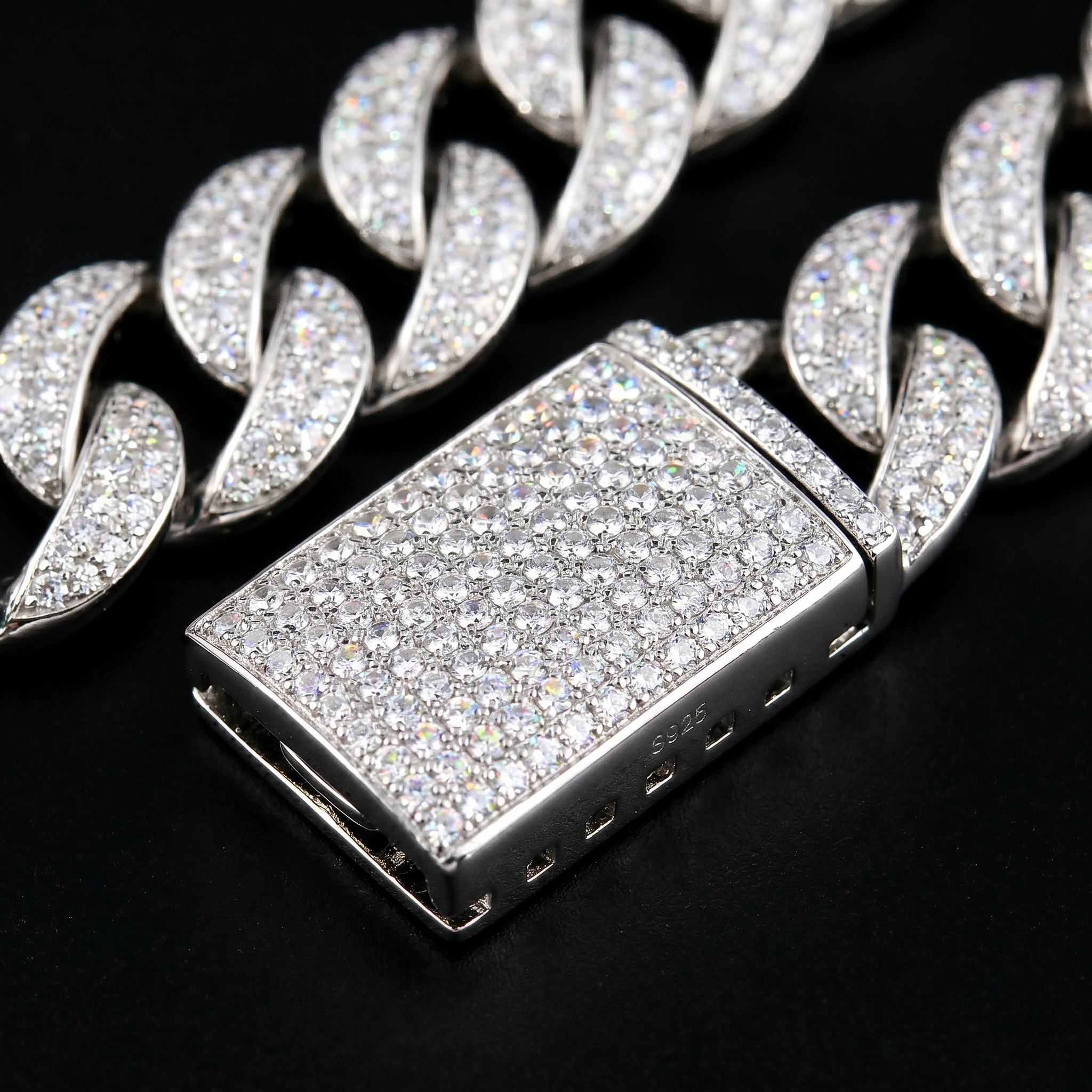 Macro photography of the secure, heavy-duty iced out box clasp on the 13mm S925 silver moissanite Cuban chain, featuring flawless micro-prong stone settings.