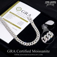 Official GRA certification card next to a 10MM S925 sterling silver Cuban link chain, with a jeweler's loupe highlighting the flawless 6A D-Color VVS moissanite stones.