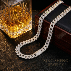 Men's luxury lifestyle shot featuring the 10MM iced out moissanite Cuban chain next to a crystal whiskey decanter and a vintage wooden box.