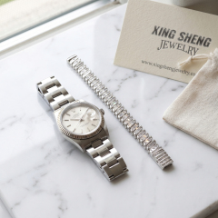 The 8mm baguette moissanite link bracelet styled gracefully next to a luxury watch, demonstrating premium lifestyle integration and daily wearability.