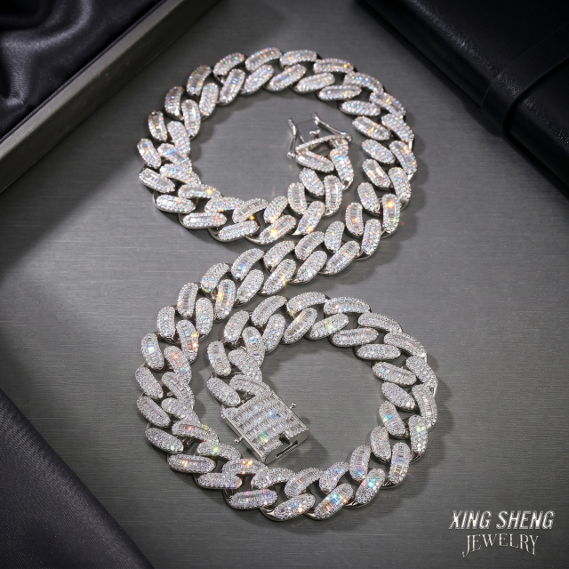 A long 14mm iced out moissanite Cuban link chain gracefully draped in an S-shape on a metallic surface, highlighting the seamless soldered links and the 0.3-micron rhodium white gold finish.
