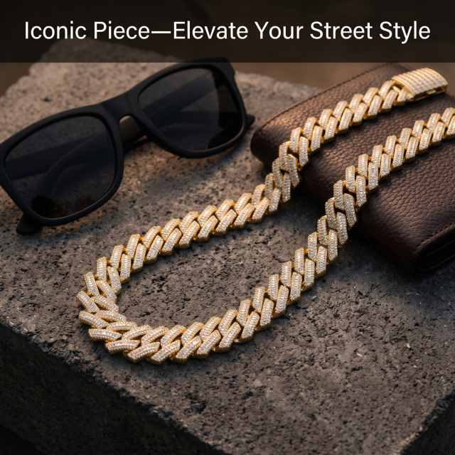 A 16mm yellow gold plated Moissanite Cuban chain presented on a textured concrete base next to luxury sunglasses and a leather wallet.