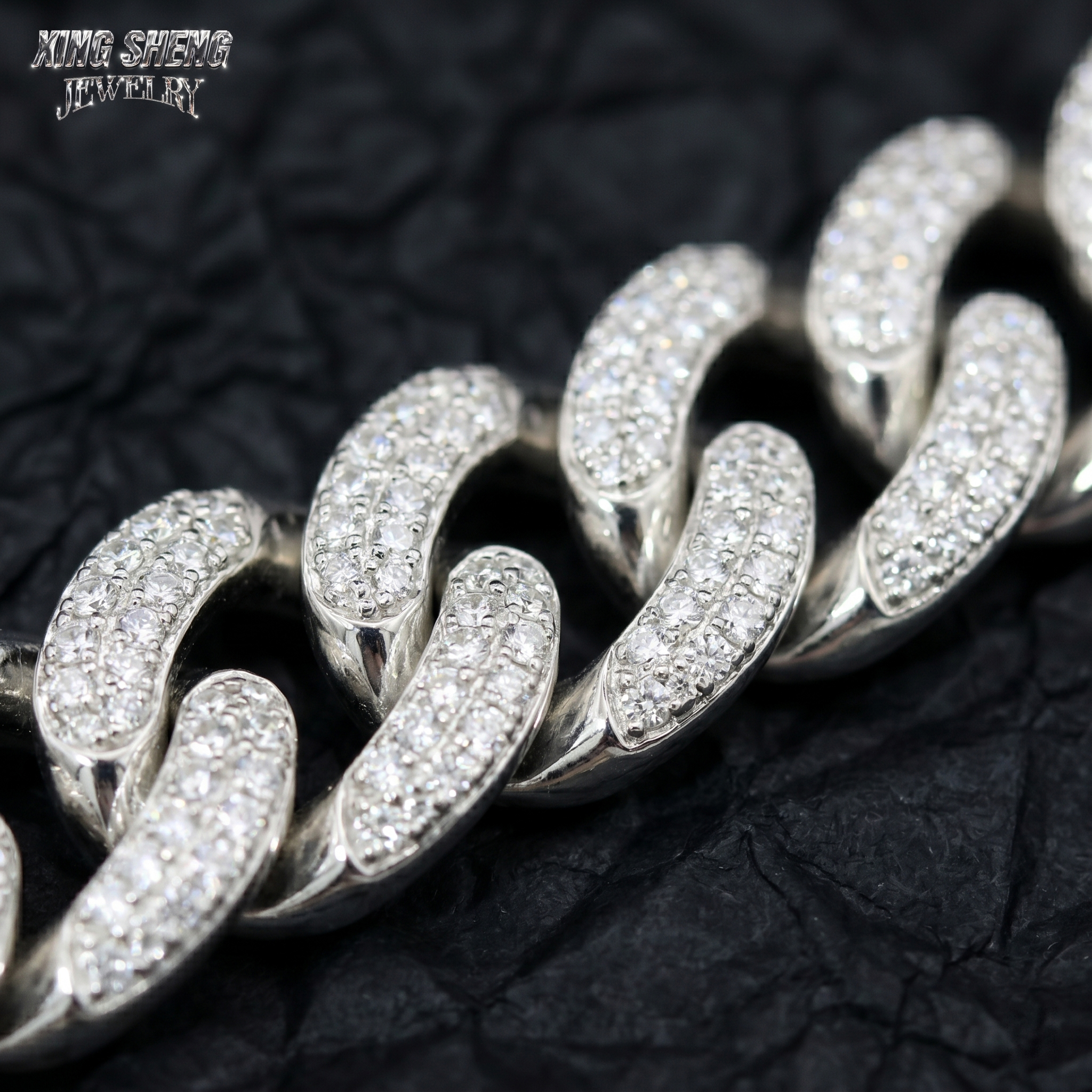 Macro photography of flawless VVS D-color moissanite stones securely set in a 10mm white gold Cuban link chain, highlighting excellent cut and professional 4-prong jewelry craftsmanship.