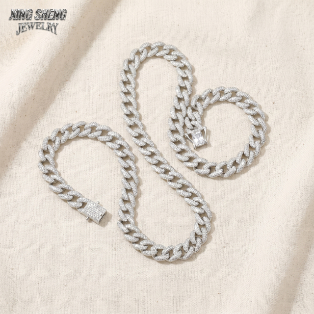A matching set of 10mm white gold plated moissanite Cuban link necklace and bracelet crafted from S925 silver, displayed on a textured linen background highlighting the secure box clasp.