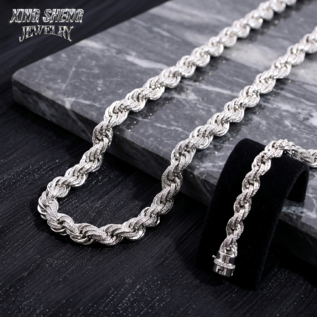 Macro close-up of excellent cut round moissanite stones meticulously set in a 10mm 3D rope chain architecture resting on black marble.