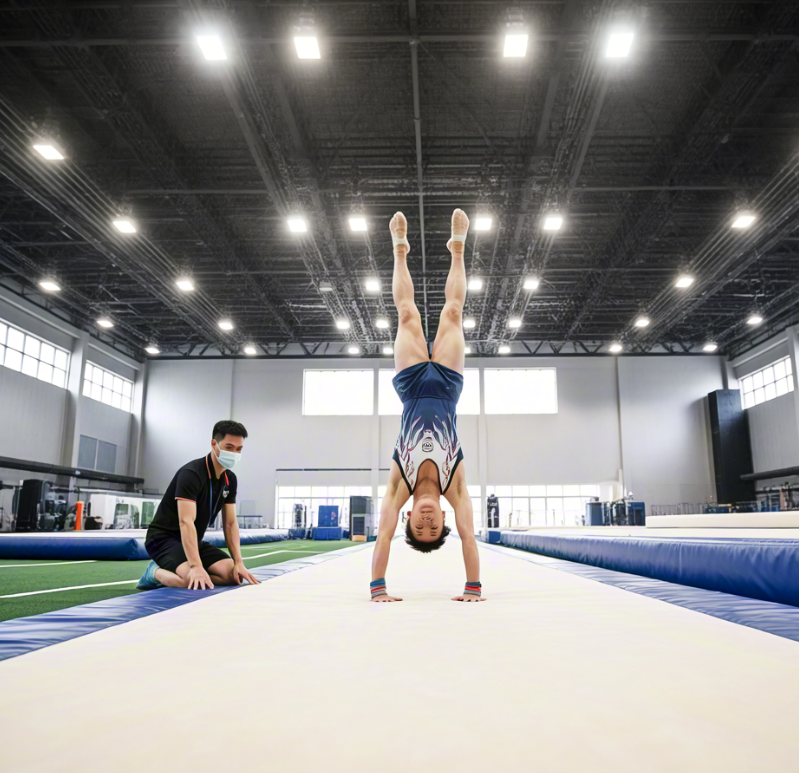 Professional gymnast training on inflatable air track with coach adjusting pressure for competitive use.