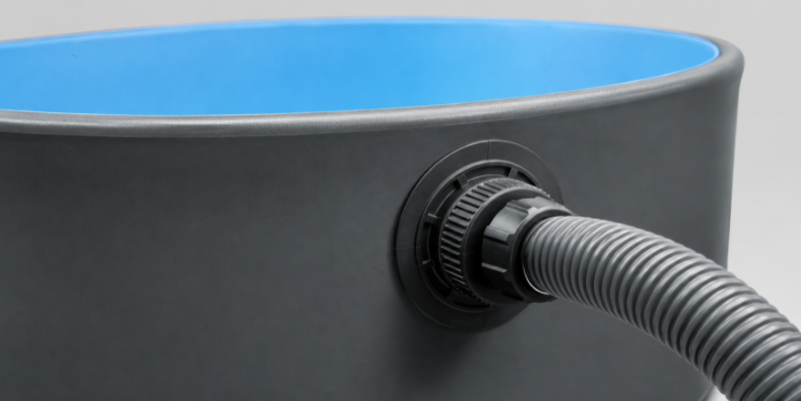 A close-up of a heavy-duty, reinforced water inlet valve on a drop-stitch pool wall connected to a professional pool filter hose.