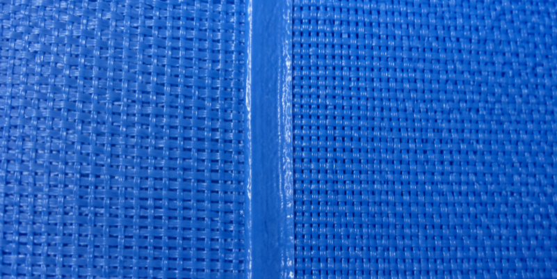 close-up of a heat welded seam on drop stitch PVC pool fabric showing mesh texture
