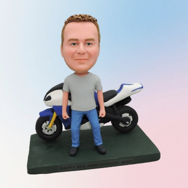 Customized bobblehead dolls standing beside motorcycles.