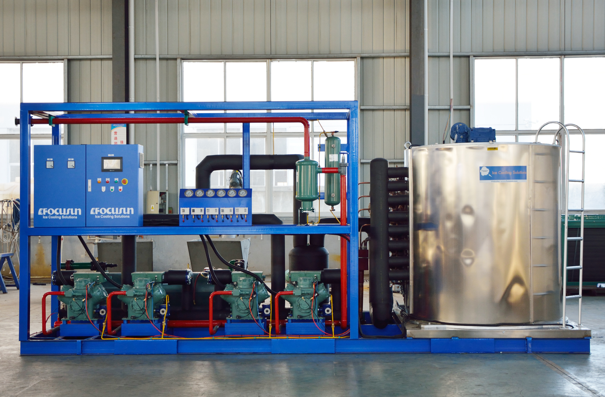 Industrial flake ice machine featuring a refrigerated drum and scraper assembly for continuous snow-like ice production.