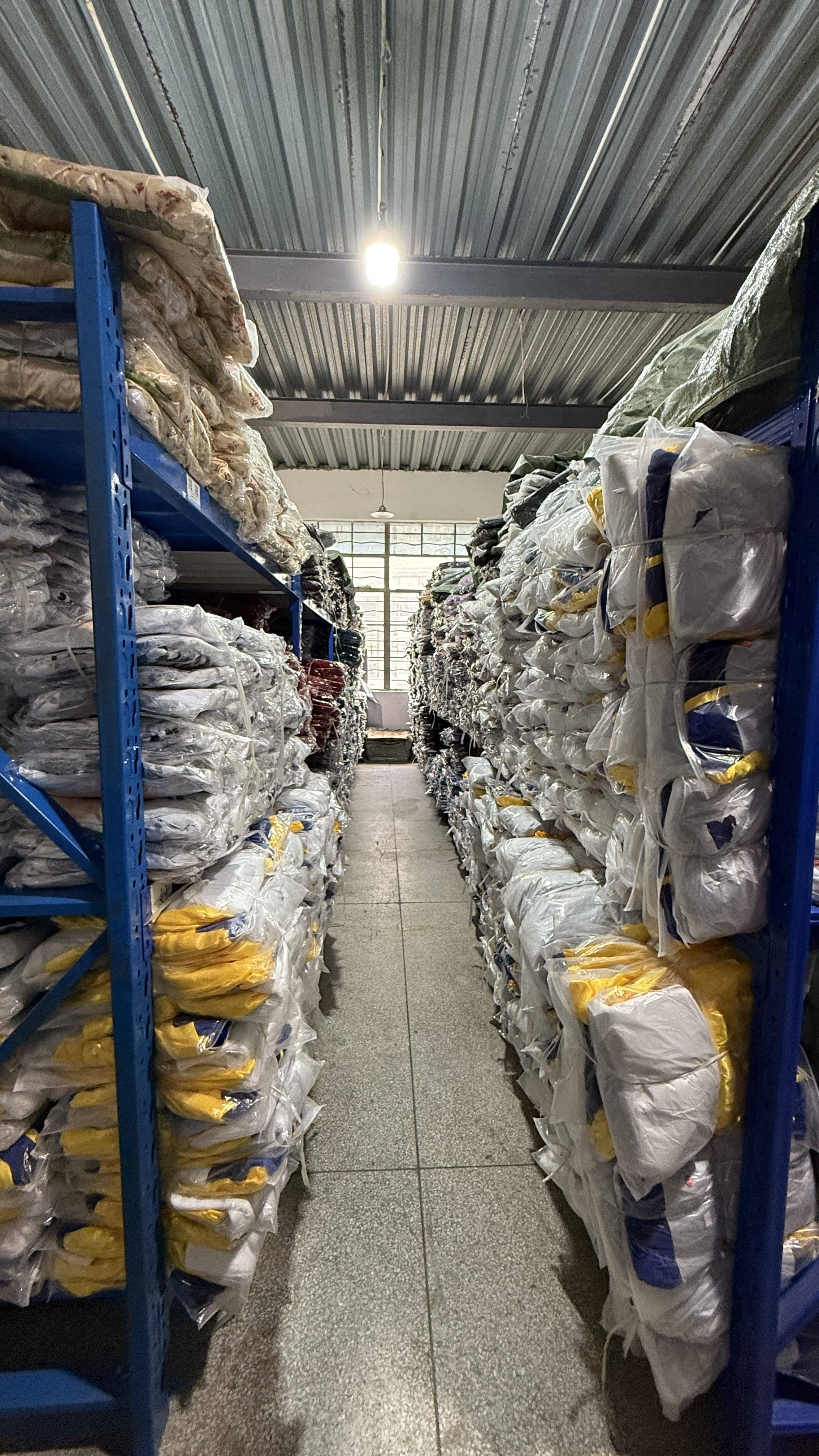 Large-scale costume storage racks showing packaged bulk inventory in factory warehouse