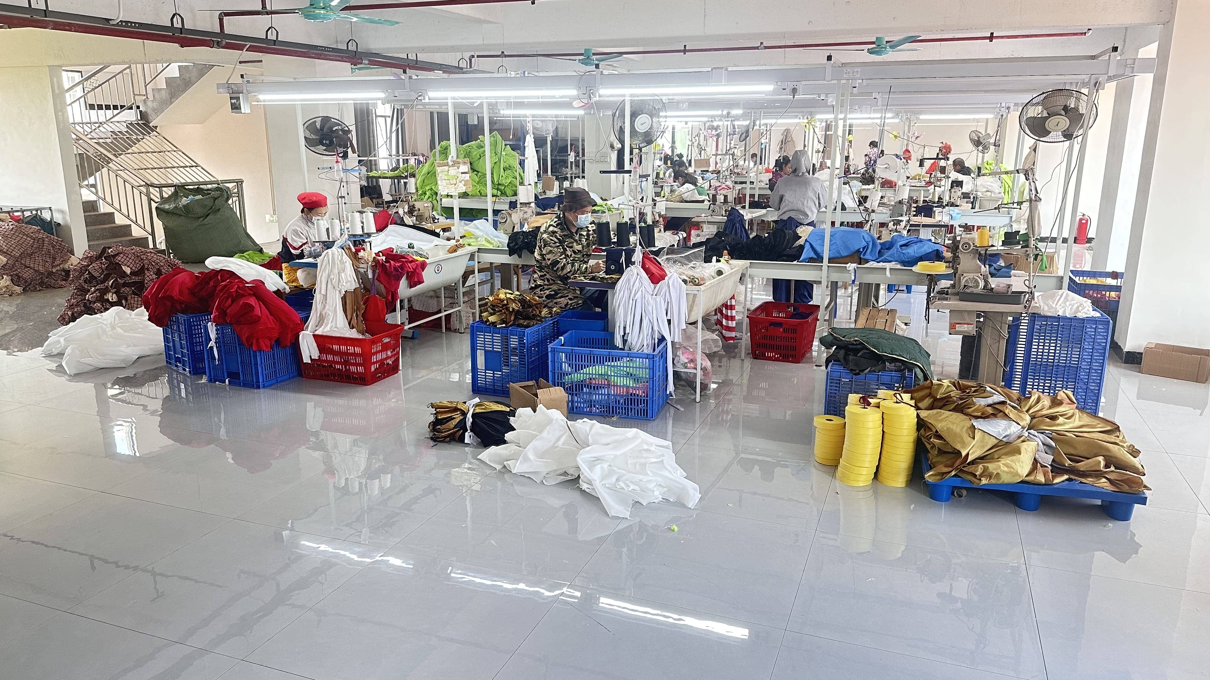 In-house costume manufacturing workshop with workers sewing garments for bulk wholesale orders