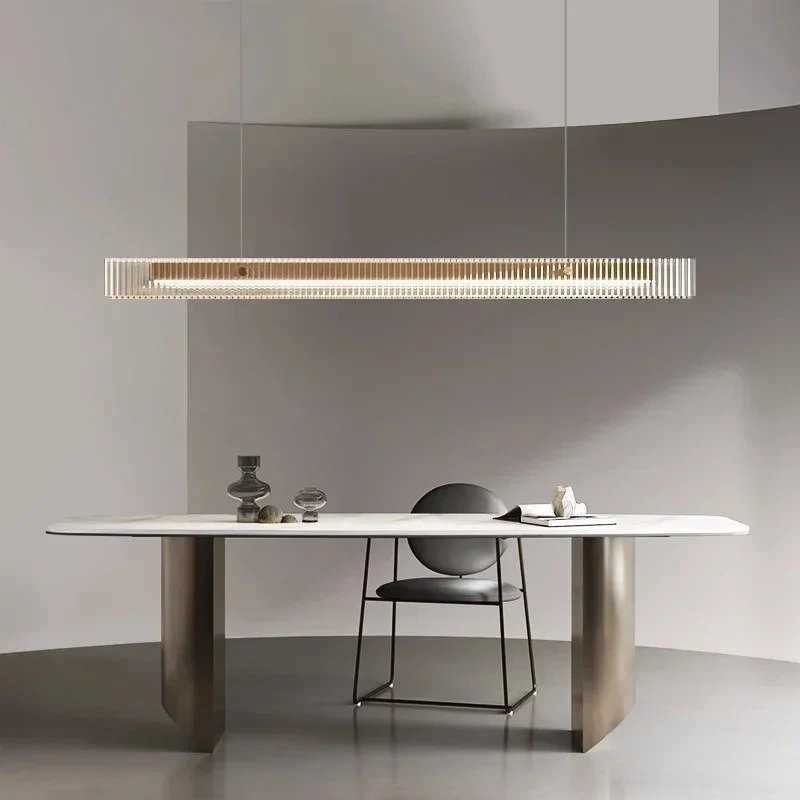 Minimalist LED linear pendant lamp hanging over a wooden dining table