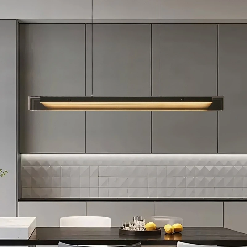 Minimalist LED linear pendant lamp hanging over a wooden dining table