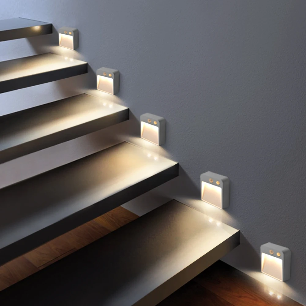 Battery powered LED night lights illuminating indoor stair treads