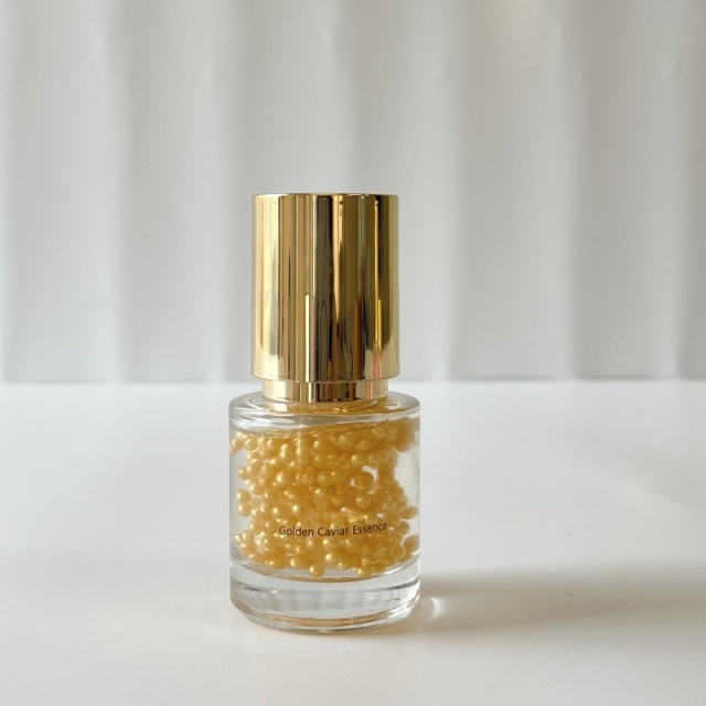 Bulk Golden Caviar Essence single unit—transparent glass bottle with golden lid, holding golden beaded essence, applicable for B2B beauty distributor & private label skincare solutions