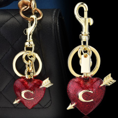 This keychain features a romantic heart in red glitter with gold arrows and lettering. The metal hook and ring design is sturdy and durable