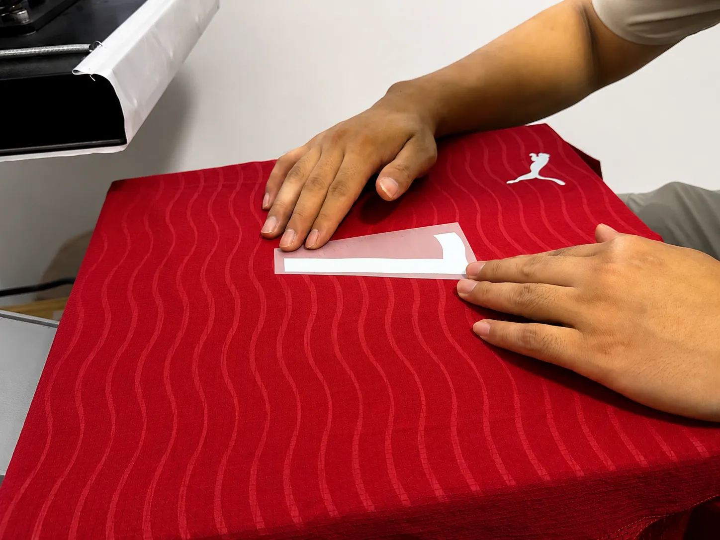 Front jersey number being positioned before heat pressing