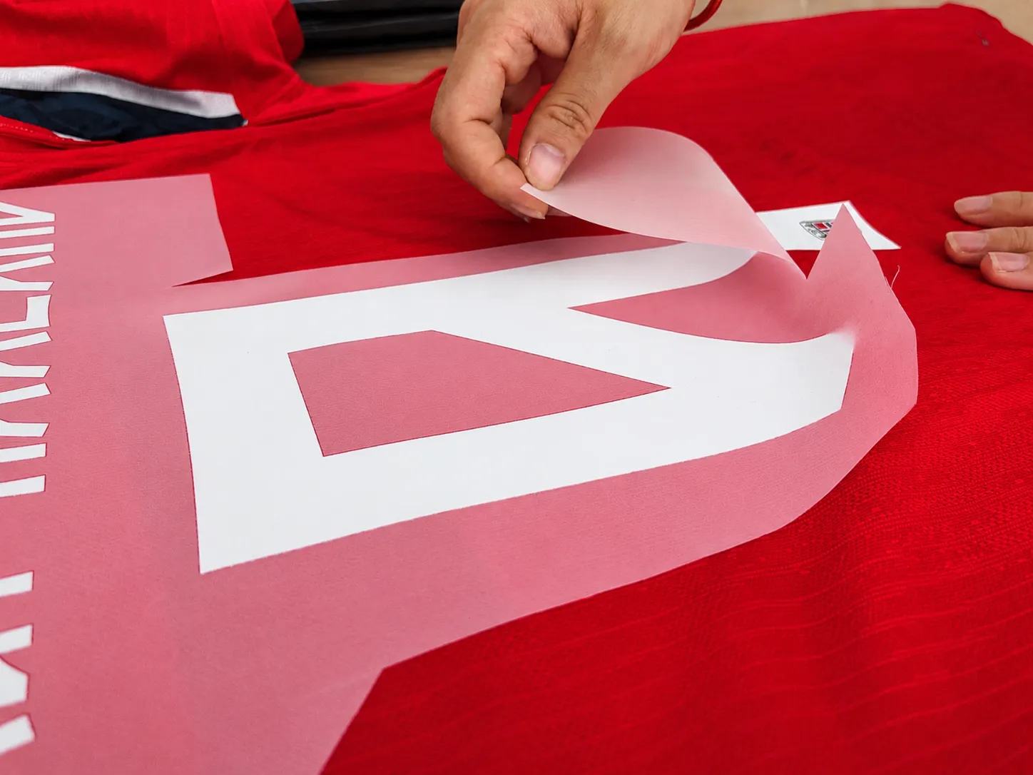 Transfer film being removed before final customized jersey inspection