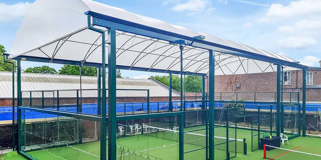 Covered padel court with roof structure and enclosed playing area