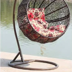 Charming Dark Rattan Swing Chair with Floral Patterned Cushion for Lakeside Relaxation,Romantic White Rattan Swing Chair with Heart-Shaped Red Cushion for Beachside Serenity
