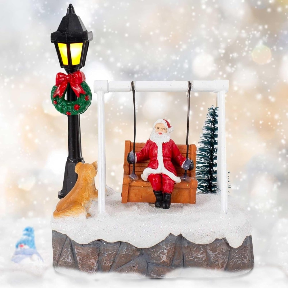 Wholesale innodept12 resin Santa swing village scene with LED lighted lamp post and festive dog figurine.