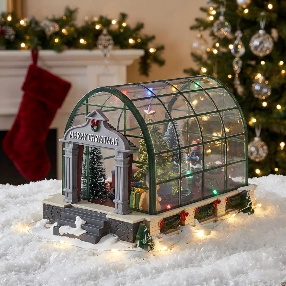 Christmas village conservatory display with festive lights in snow.