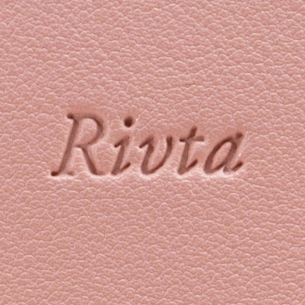 Close-up detail of debossed logo on a PU leather cosmetic bag