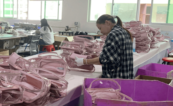 A factory worker assembling a custom bag prototype in an organized workshop