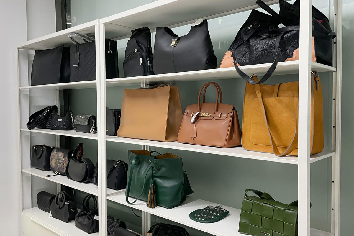 A collection of premium zipper tote bags made from various sustainable materials like cork, pineapple leather, and organic cotton, arranged in a natural sunlight setting.