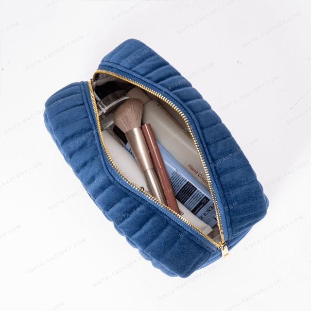Quilted airline amenity pouch opened with planned contents for fit review