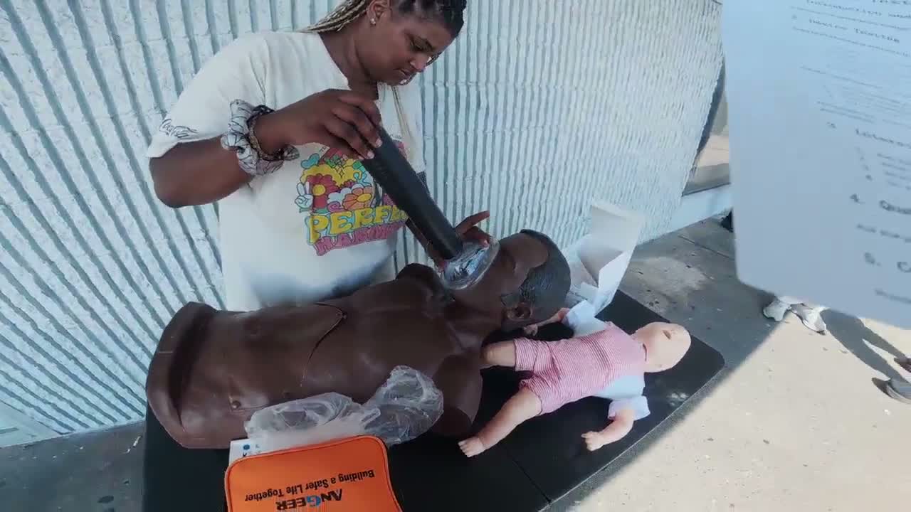 Participant handling an EasyPumpVac device at an adult torso training manikin