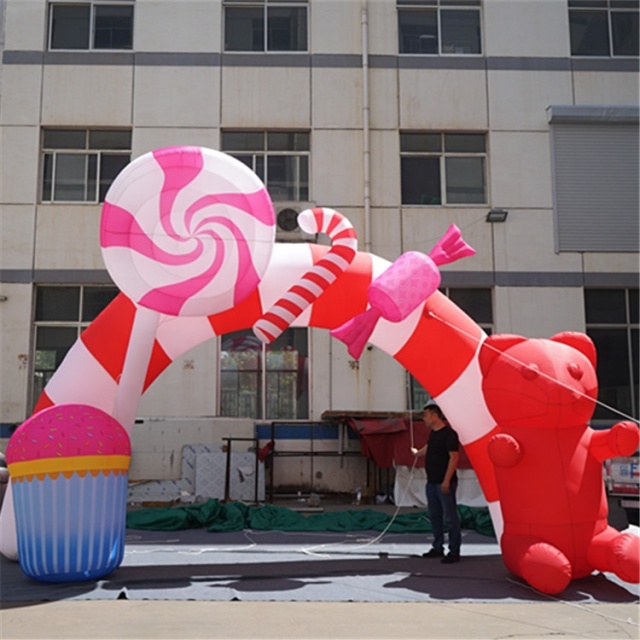 Outdoor inflatable Christmas candy cane donut arch with bows and event decorations, featuring inflatable advertising gifts.