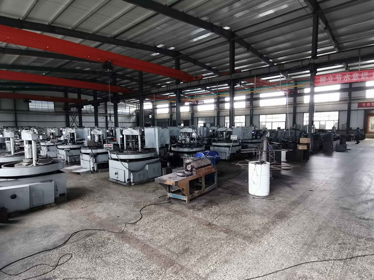 Wide factory hall with rows of machinery and red banner