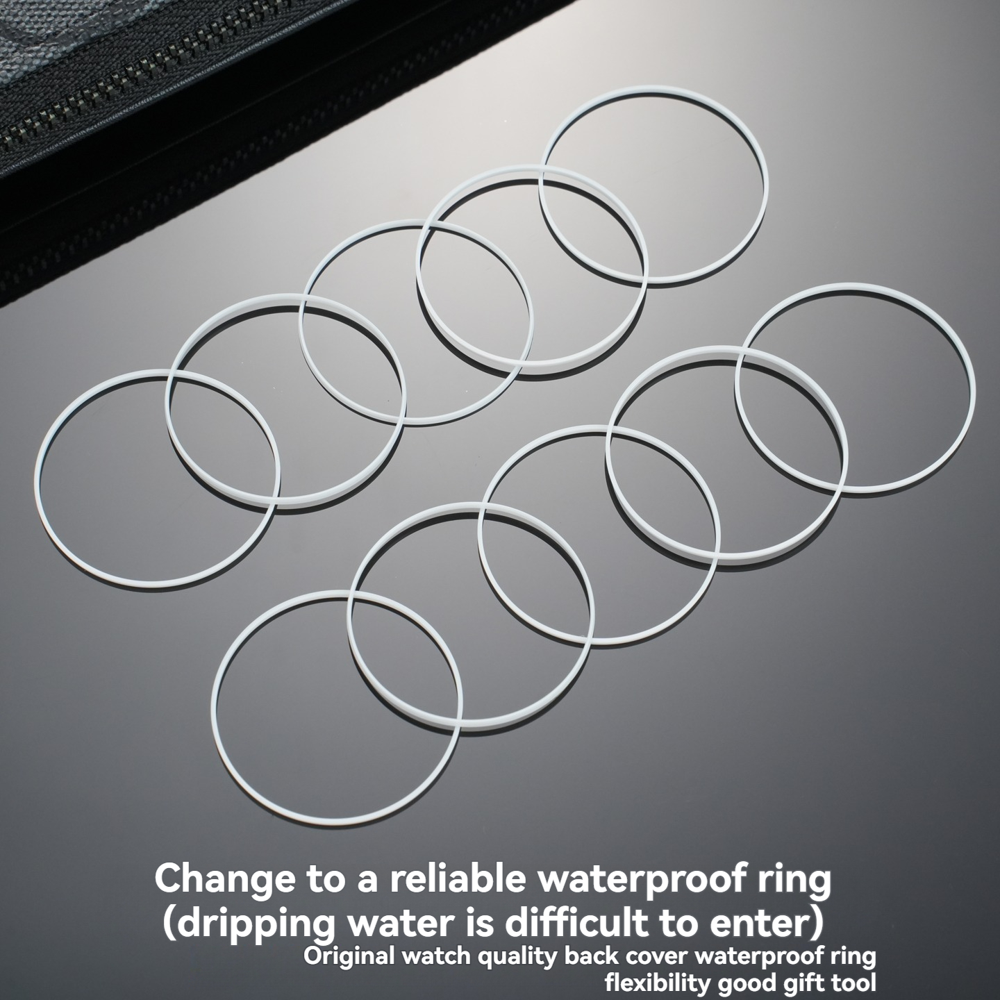 Several white gasket rings scattered on dark surface
