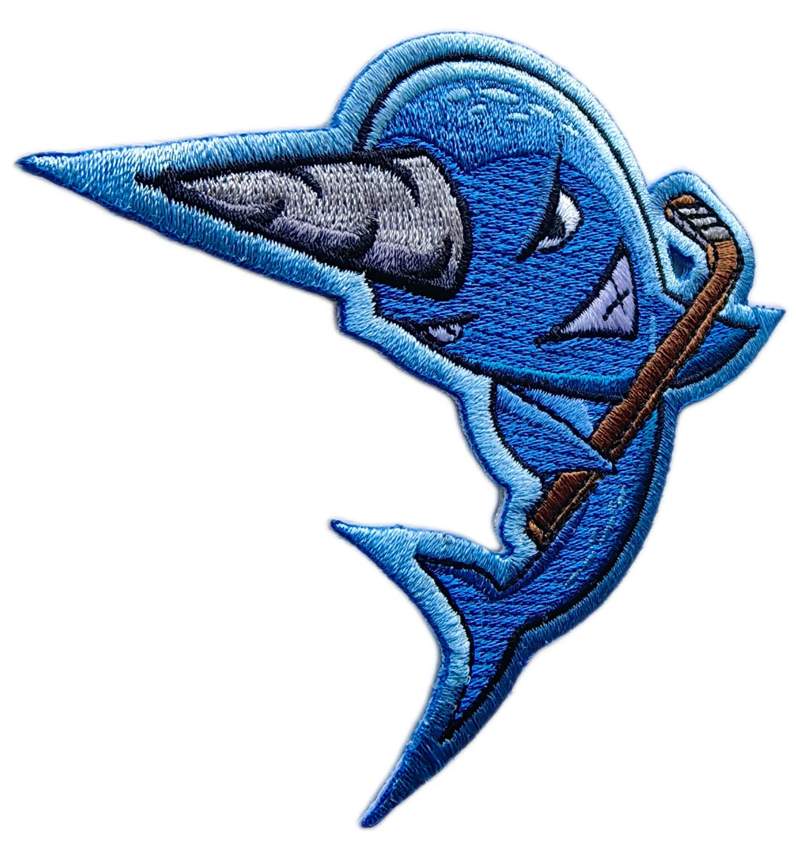 Left side view of the blue narwhal hockey mascot embroidered patch showing stitch density and merrowed border
