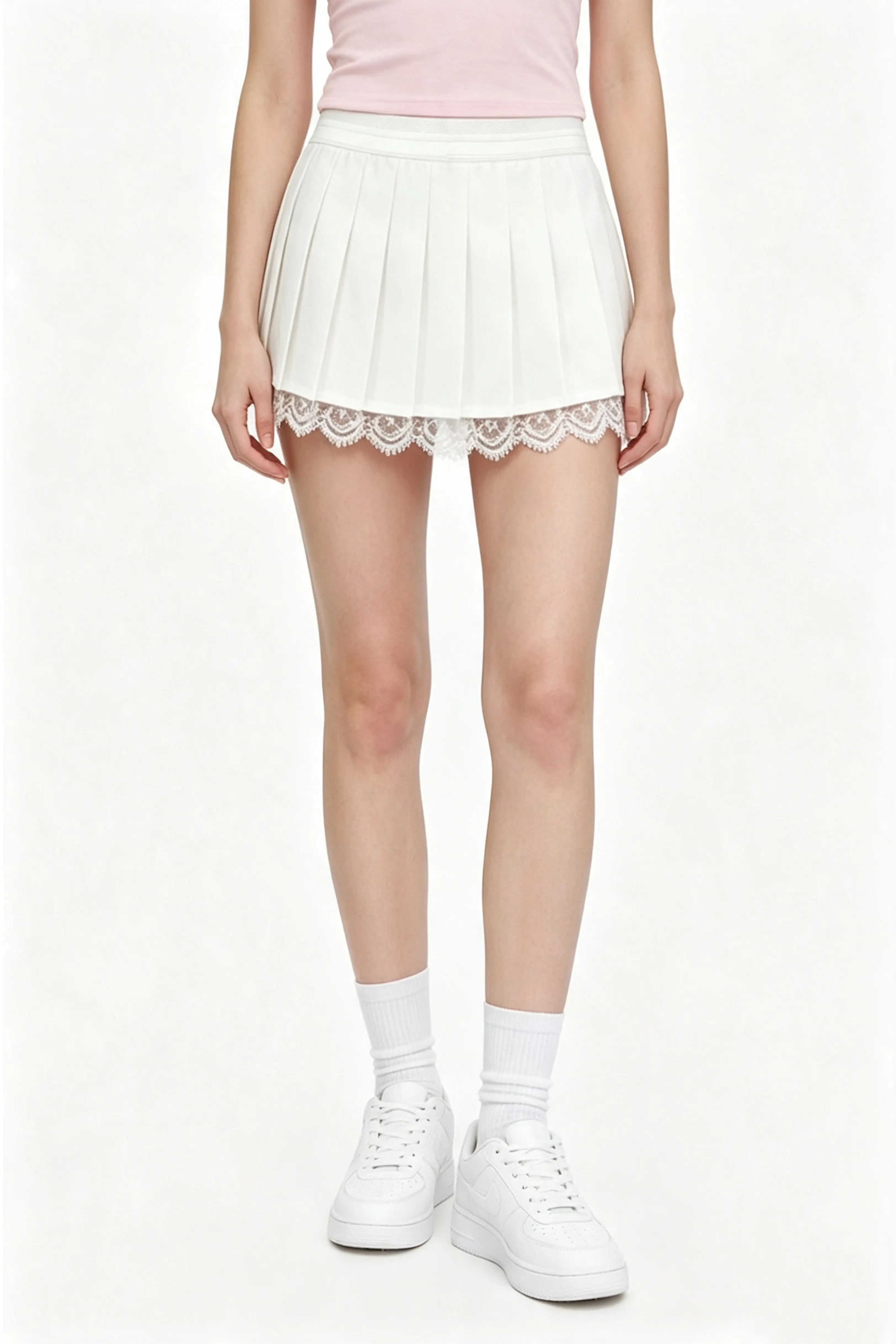 Front view of a high waisted white pleated tennis skirt with sheer lace trim detail around the hemline.