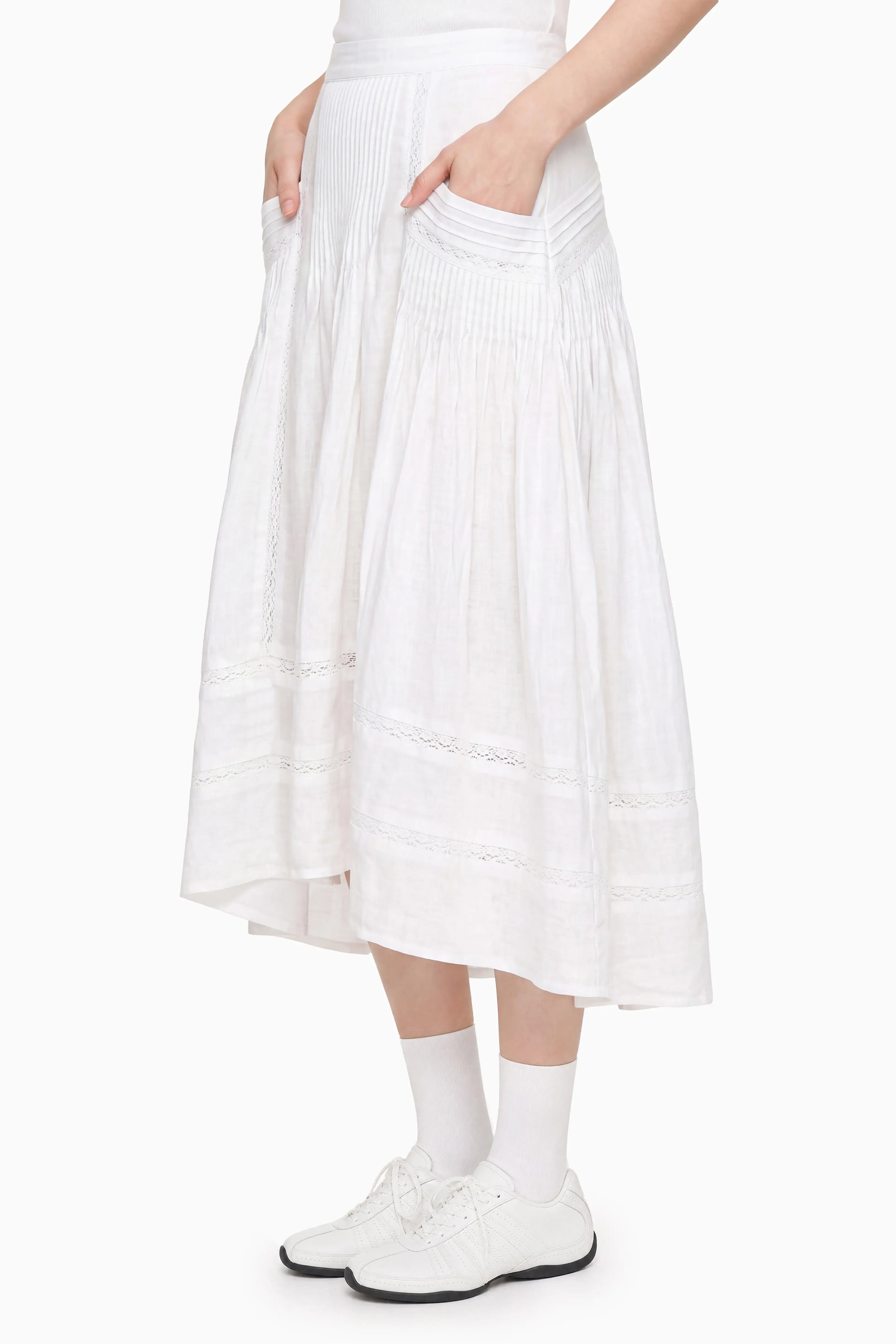 Side profile view of a model wearing a high-waisted white midi skirt, showing its relaxed silhouette and hem length.