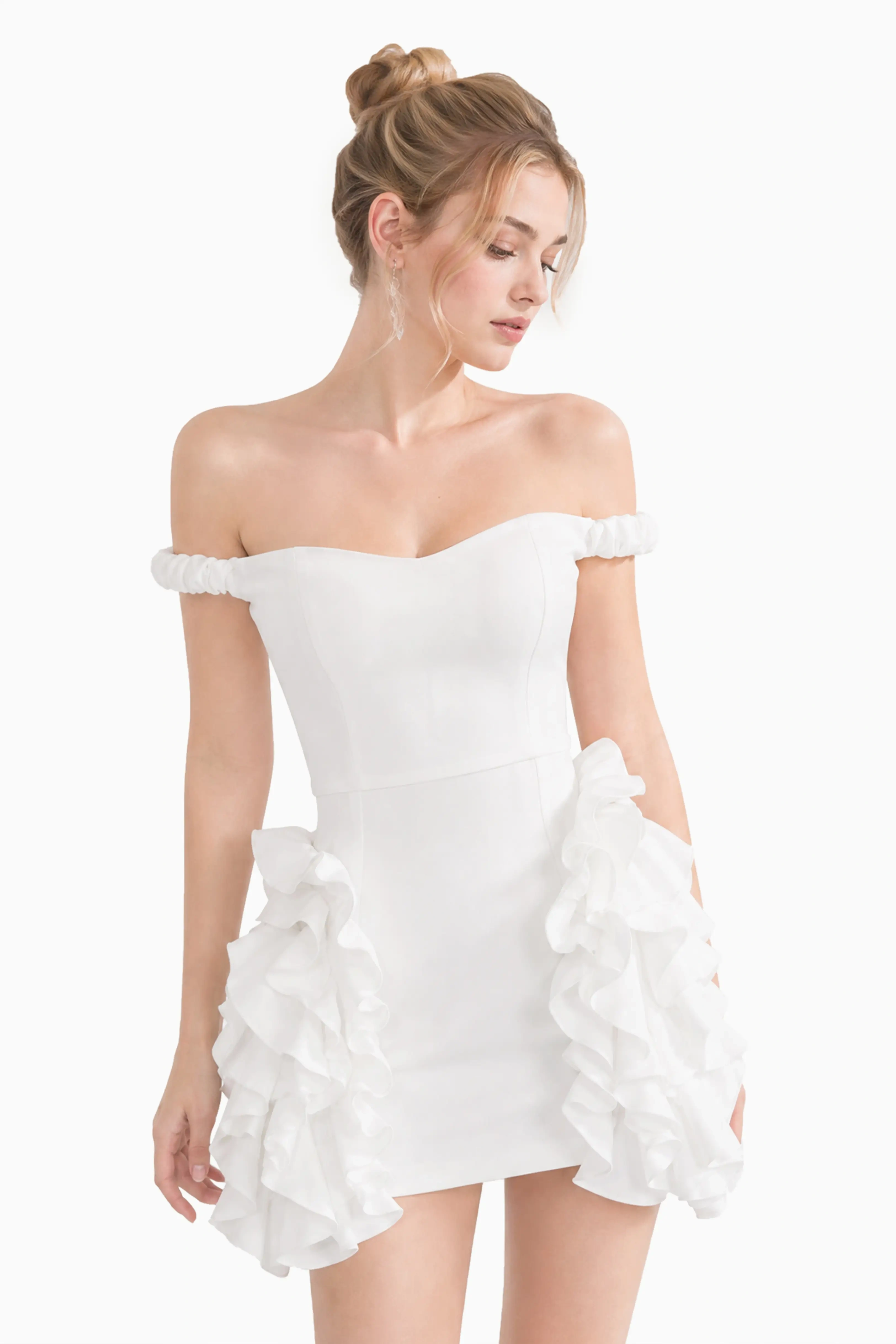 Full body shot of a model wearing an off-the-shoulder white ruffle mini dress with layered side cascades.
