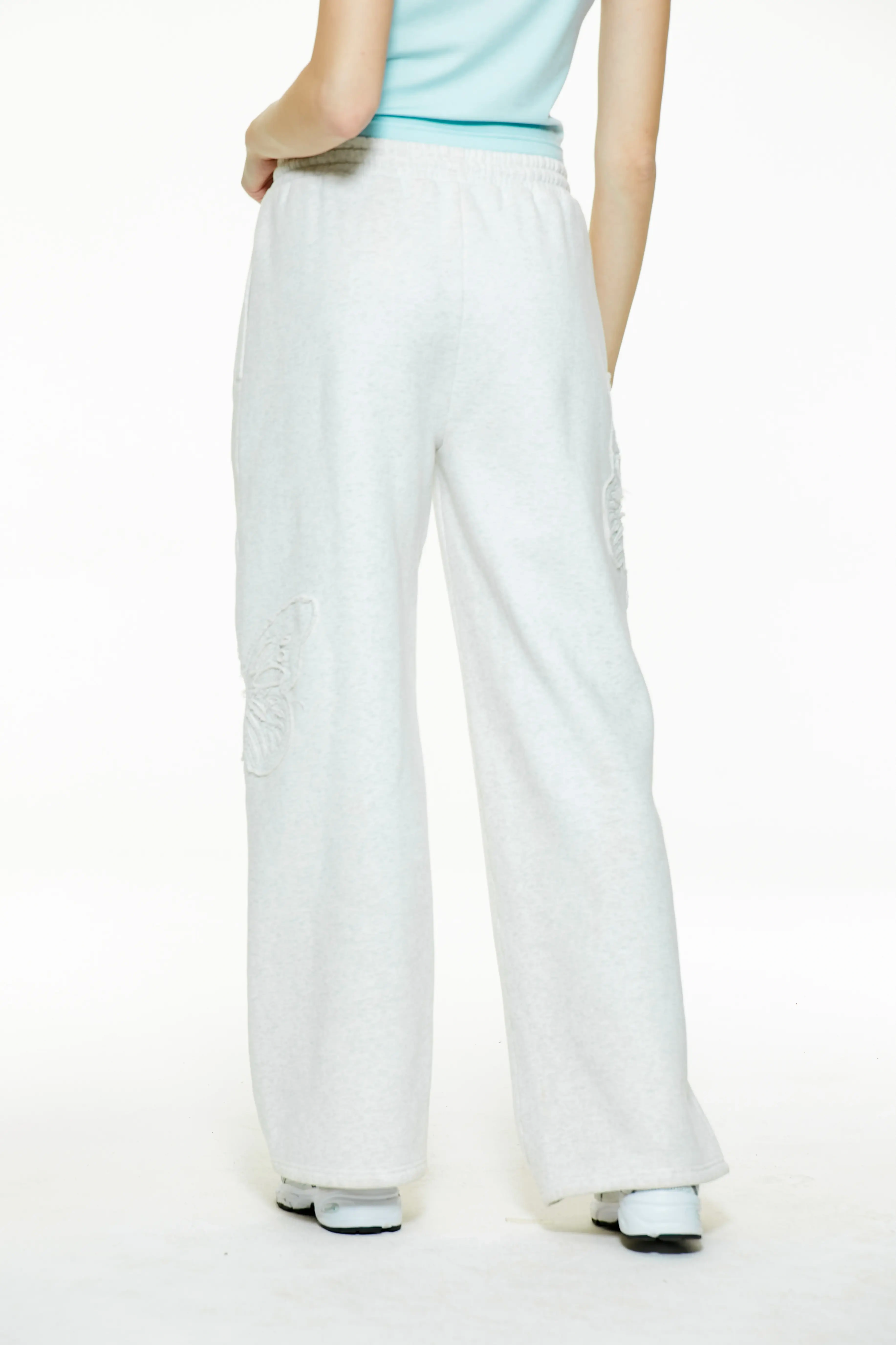 Back view of high-waisted heather grey wide-leg butterfly sweatpants showing the clean rear silhouette and straight drape.