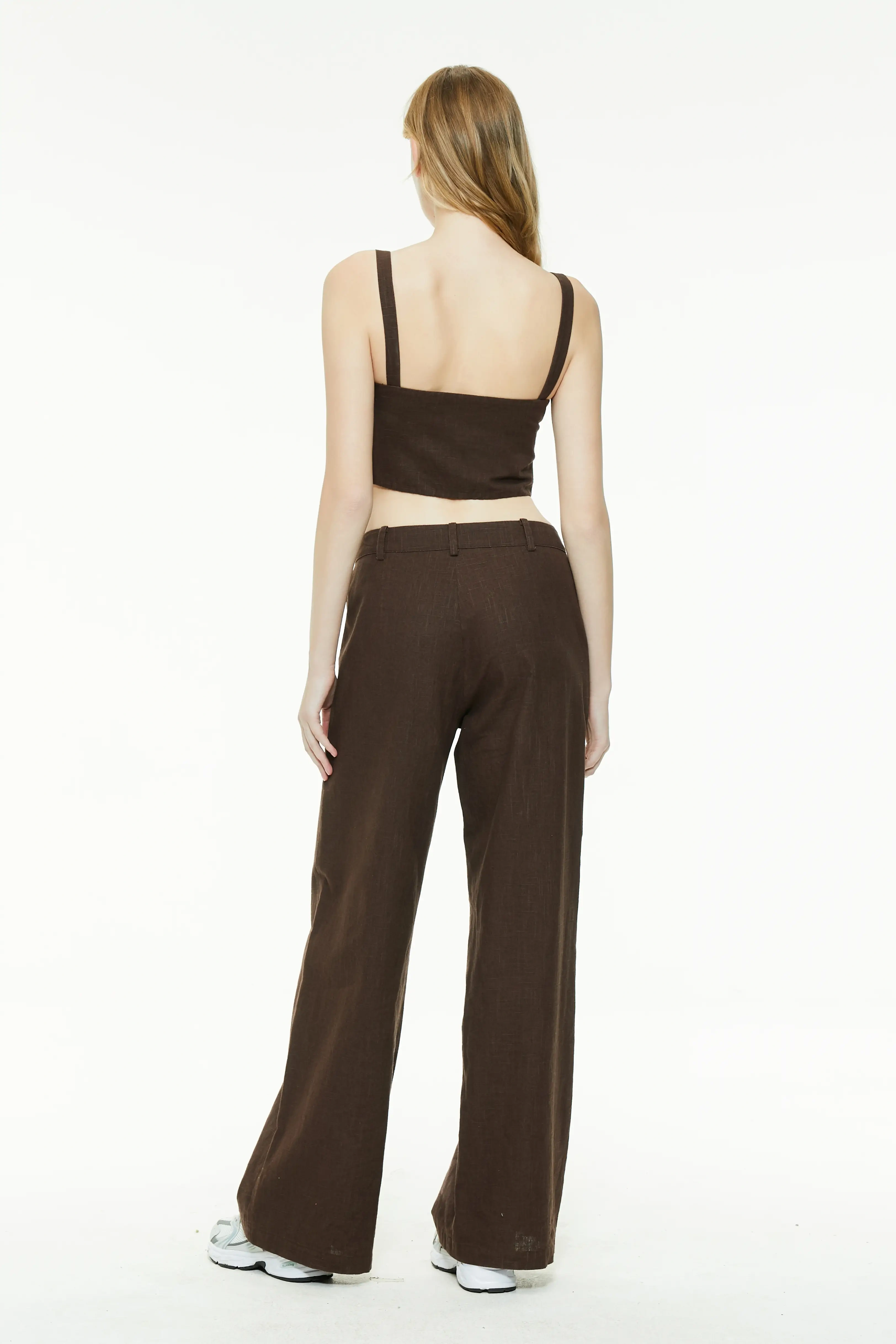 Back view of a brown linen set showing the back of the square-neck crop top and wide-leg trousers.